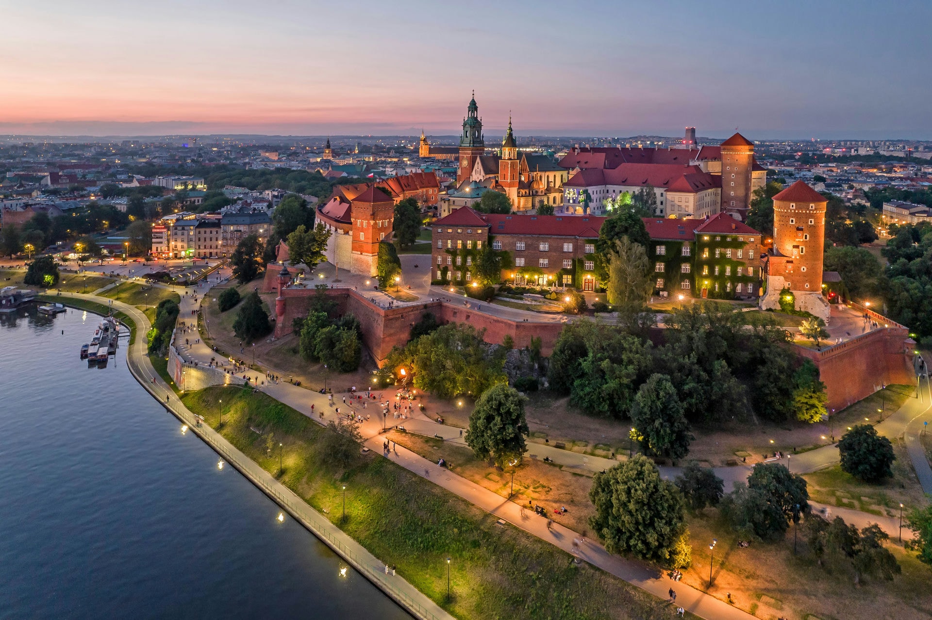 Wieczorny widok z lotu ptaka na Wawel w Krakowie nad Wisłą, z oświetlonym zamkiem i katedrą