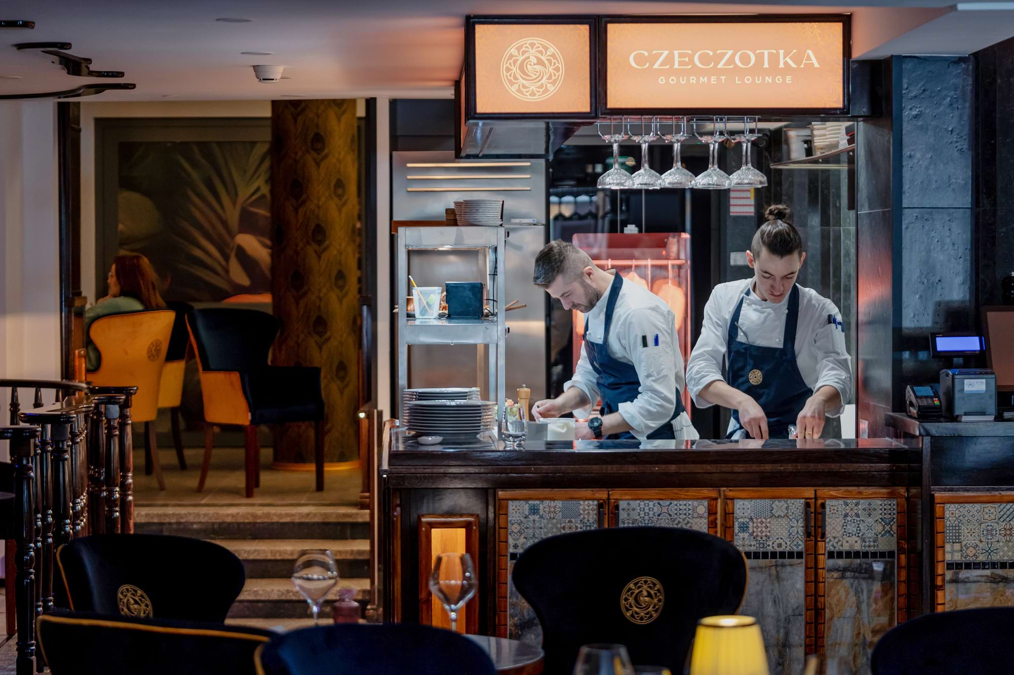 Dwaj kucharze pracują przy barze w eleganckiej restauracji Czeczotka Gourmet Lounge